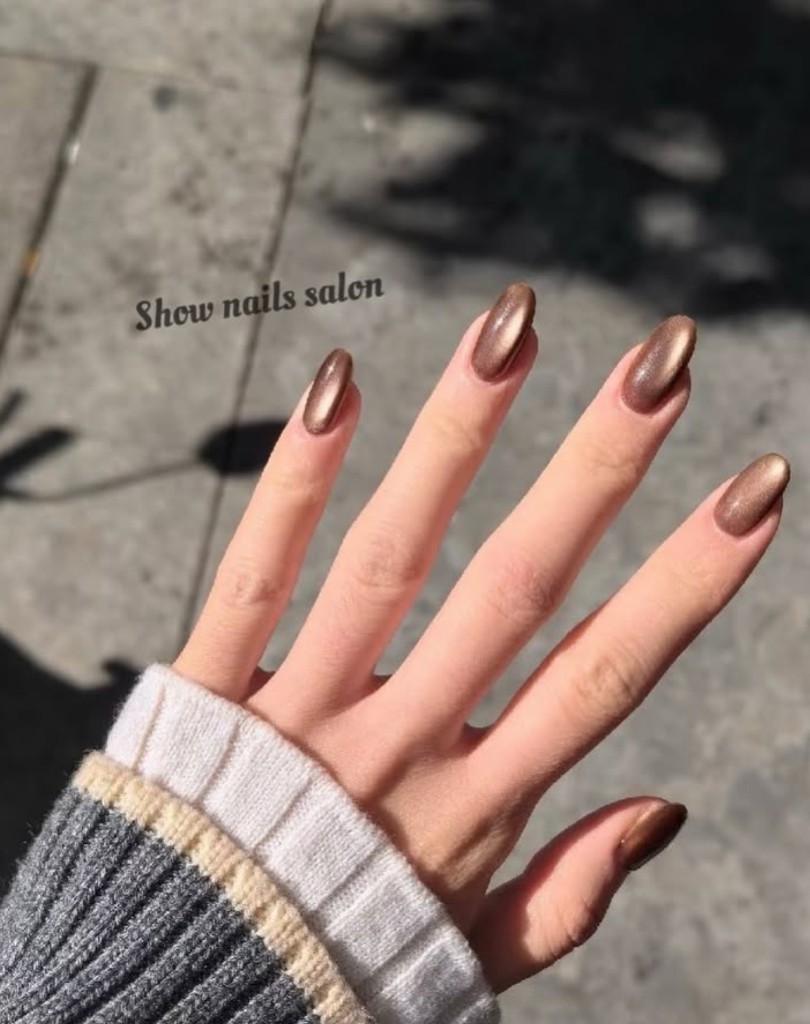 Long bronze metallic cat-eye manicure in natural light