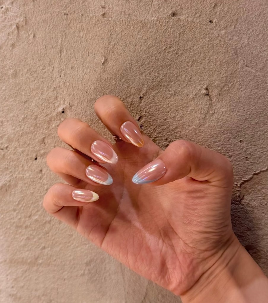 Iridescent chrome finish with soft pastel French tips on almond nails